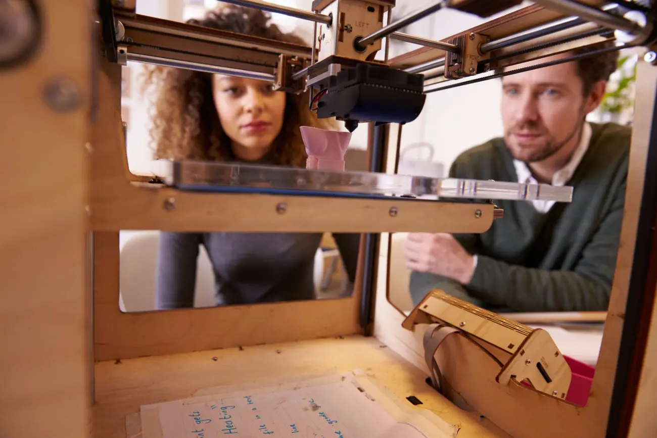 People observing a 3D printer in action.